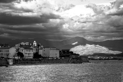 View of cityscape against cloudy sky