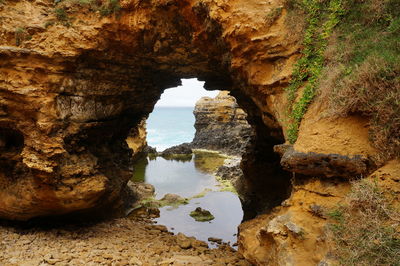 Rock formations in sea seen through cave