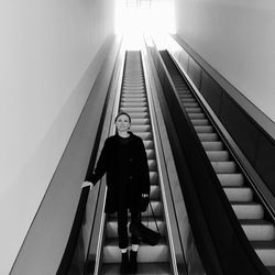 Portrait of woman standing on escalator