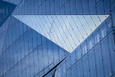 Low angle view of modern building against blue sky