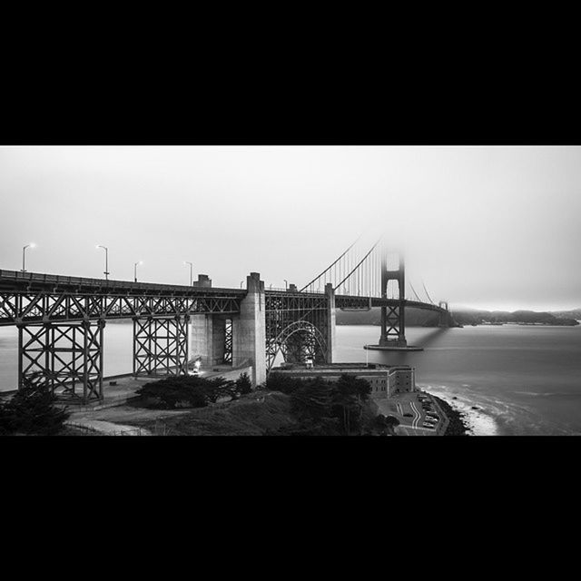 built structure, water, sea, architecture, connection, bridge - man made structure, clear sky, copy space, suspension bridge, bridge, engineering, sky, beach, horizon over water, railing, nature, river, silhouette, outdoors, shore