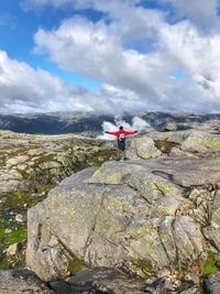 Man standing on rock mountain against sky