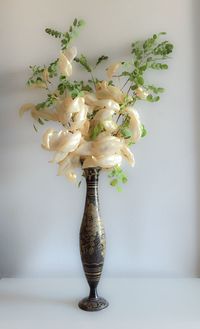 Artificial flowers in vase on table