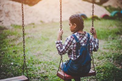 Girl sitting on swing at park