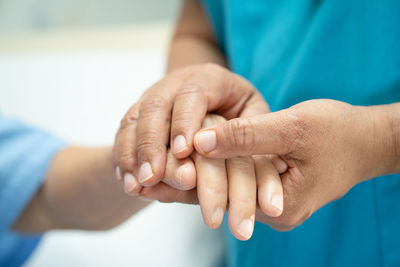 Midsection of couple holding hands