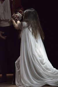 Violent man pulling woman in white dress