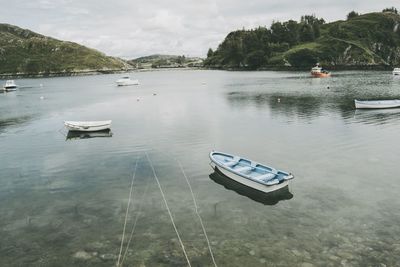 Boat moored on lake against sky