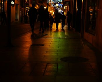 People walking in illuminated city at night