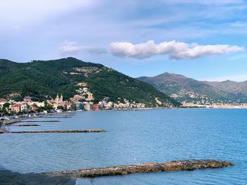 Scenic view of sea by buildings against sky