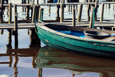 Green wooden fishing boat on pier