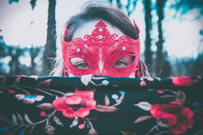 Close-up portrait of woman wearing eye mask standing against trees