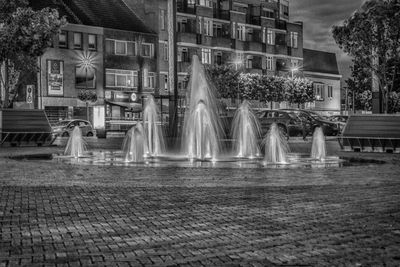 Fountain in front of building at night