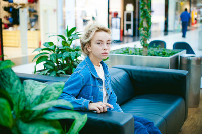 Portrait of young woman sitting on sofa