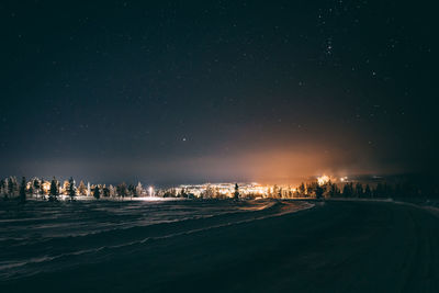 Illuminated city against sky at night