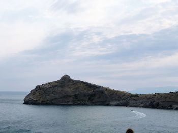 Rock formations by sea against sky