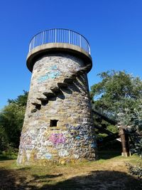 Low angle view of old tower against clear blue sky