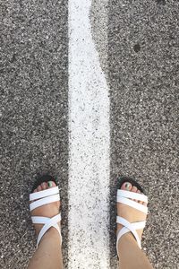 Low section of woman standing on road