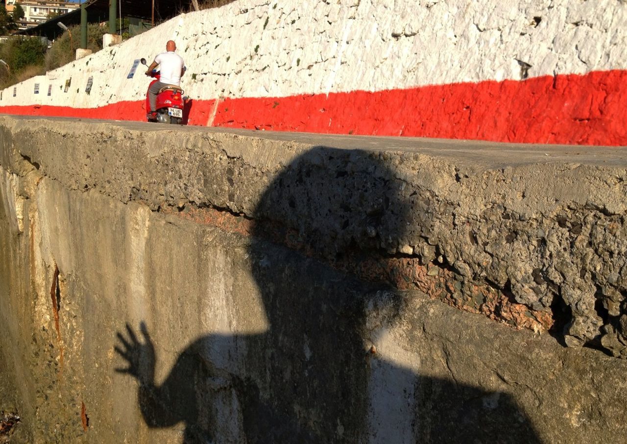 lifestyles, architecture, built structure, leisure activity, shadow, building exterior, water, men, person, sunlight, walking, street, outdoors, standing, unrecognizable person, day, reflection, high angle view
