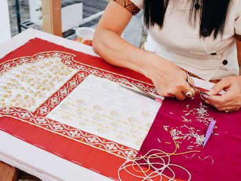 Midsection of woman embroidering jewelry