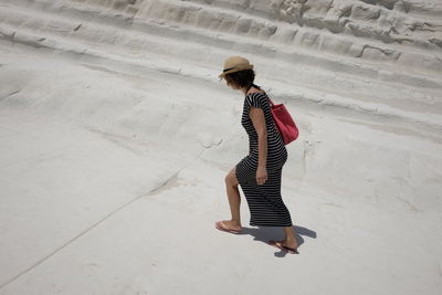 Full length of woman walking on sand at beach