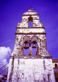 Low angle view of bell tower against blue sky