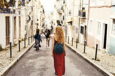 Woman walking against house