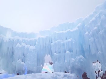 Panoramic view of ice castle against sky during winter
