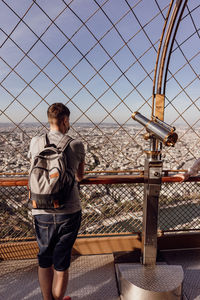 Portrait of young man standing against railing