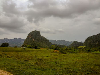 Rock formations on landscape against cloudy sky