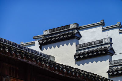 Low angle view of old building against clear blue sky
