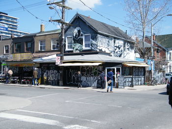 People on street against buildings in city