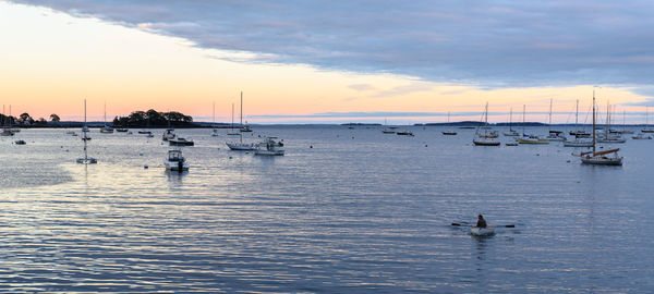 Silhouette sailboats in sea against sky during sunset