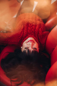 Portrait of a young woman in a warm knitted red sweater outside