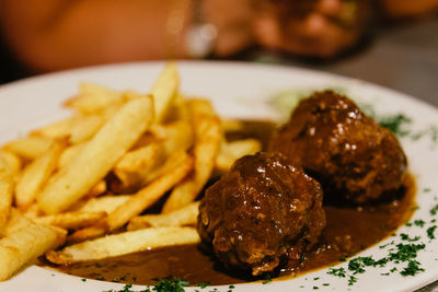 Close-up of meatballs with french fries served in plate