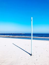 Scenic view of beach against clear blue sky