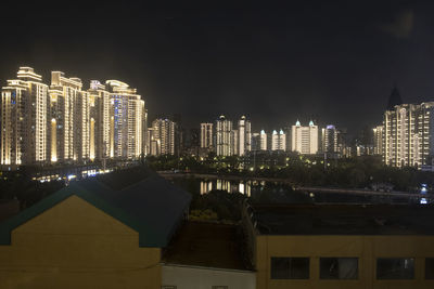 Illuminated buildings in city against sky at night