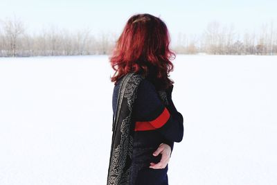 Side view of woman standing on snow covered field