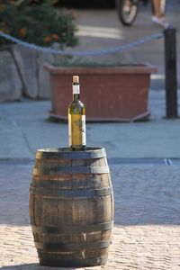 Wine bottle on barrel over footpath