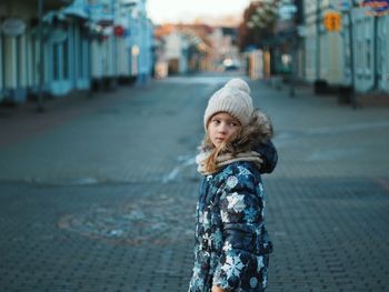 Portrait of a boy standing on street in city