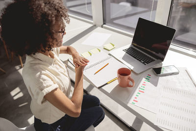 High angle view of woman using laptop at office