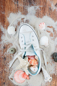 High angle view of shoe and seashells with sand on floor