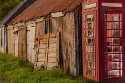 Old telephone box at the end of some corrugated metal huts