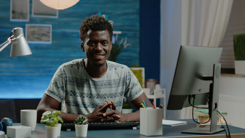 Portrait of young man sitting by table