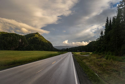 Road amidst green landscape against sky