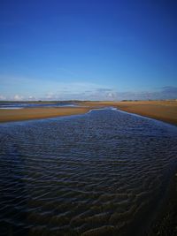 Scenic view of sea against blue sky