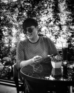 Woman wearing sunglasses while sitting at table