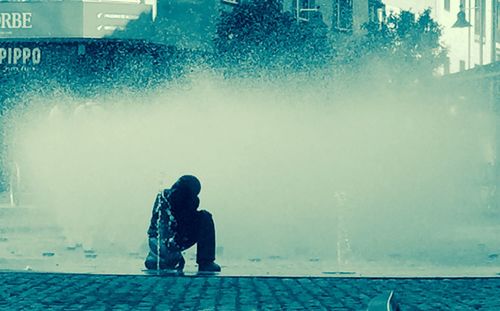 Rear view of woman in fountain