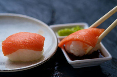 Close-up of sushi in plate by soya sauce on slate