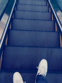 Low section of person standing on escalator