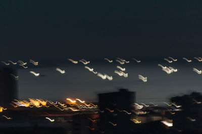 Low angle view of illuminated city against sky at night